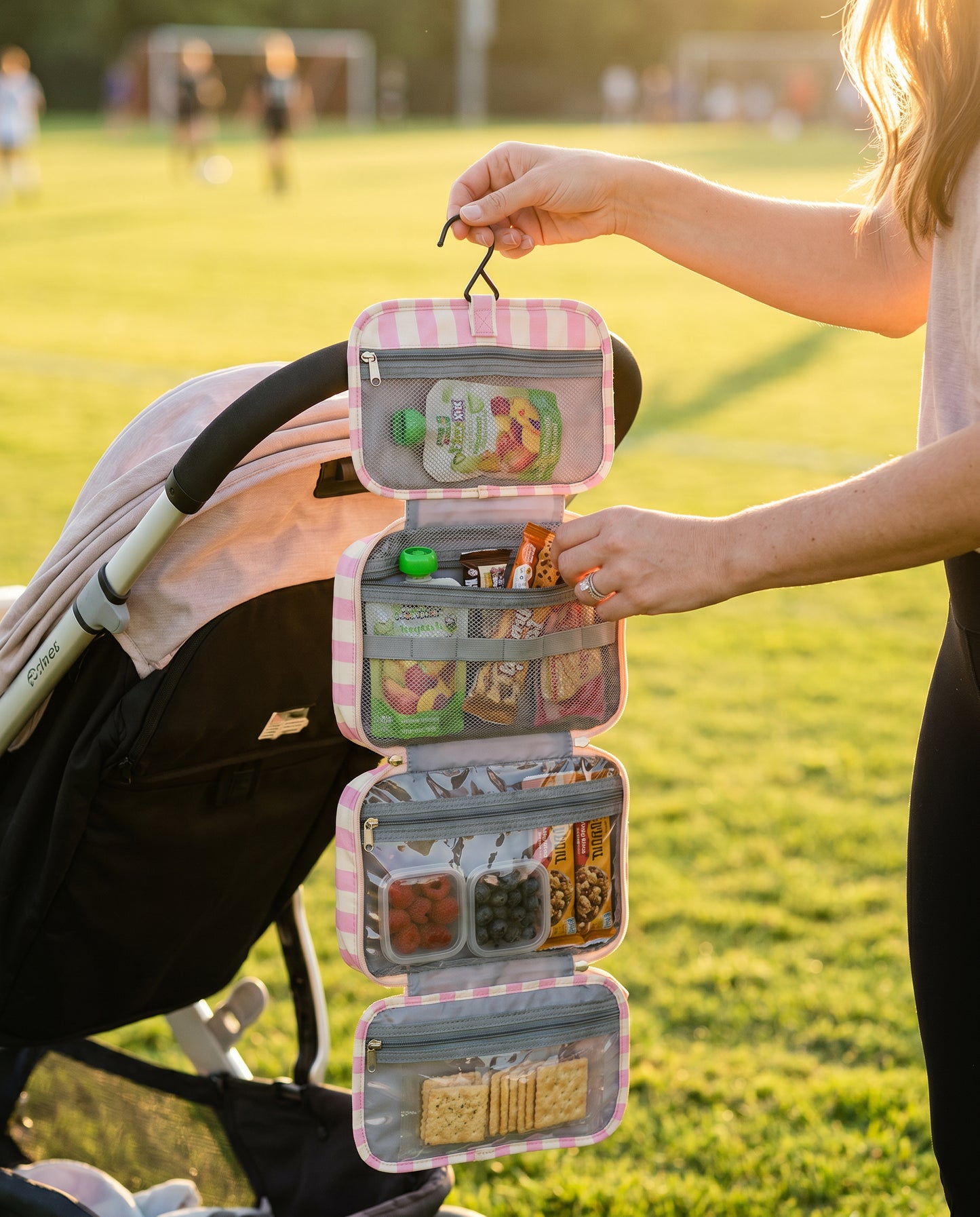 Mama Snack Bag hanging from stroller at sports field